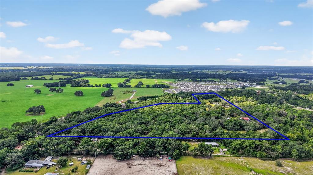 An aerial view shows a large, wooded plot of land outlined in blue — 1862 S US 301, SUMTERVILLE, FL