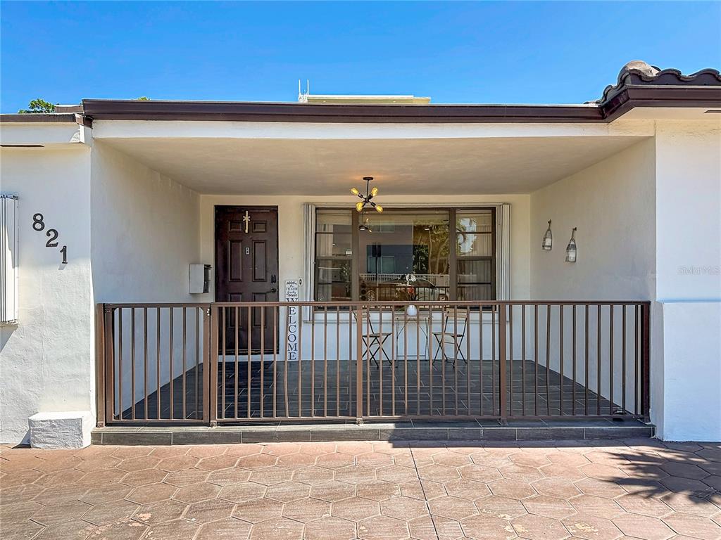 The backyard features a house exterior, a stone pathway, palm trees, and a wooden fence — 821 83RD ST, MIAMI BEACH, FL