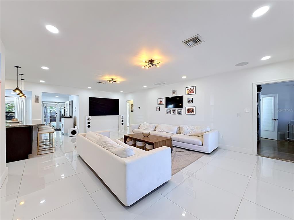 A covered front porch features a metal railing, tiled flooring, and a dark entry door — 821 83RD ST, MIAMI BEACH, FL