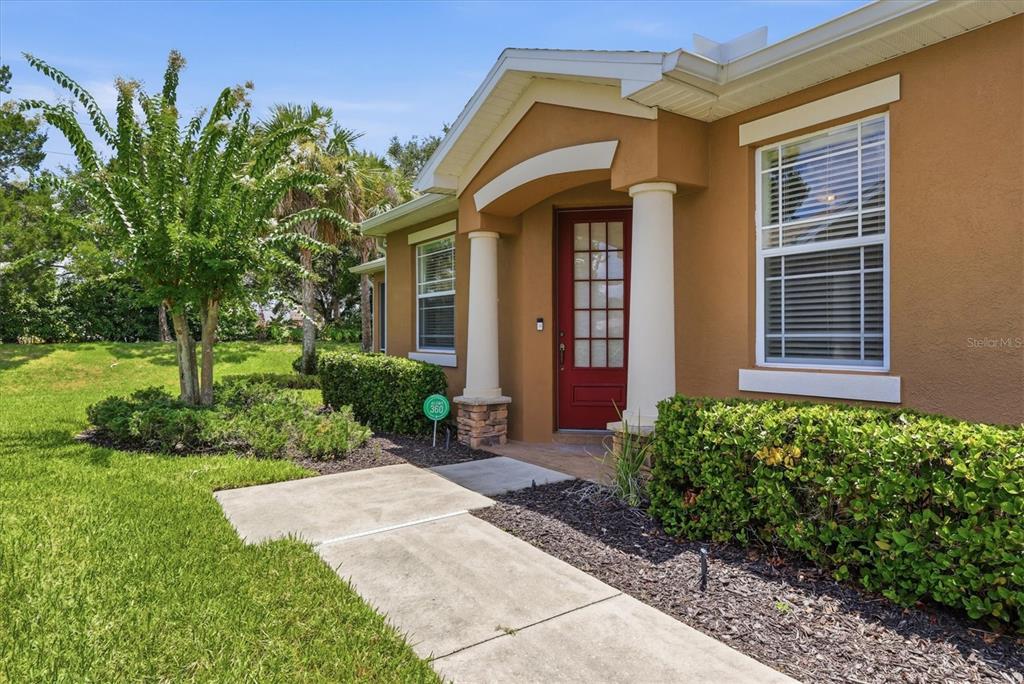 The exterior of a tan house features a red front door and two white columns — 11487 52ND COURT E, PARRISH, FL