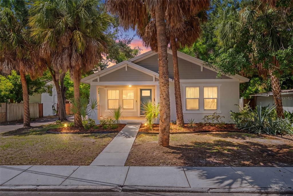 A single-story house with a gray exterior, a front porch, and palm trees in the yard — 325 WISCONSIN COURT S, ST PETERSBURG, FL