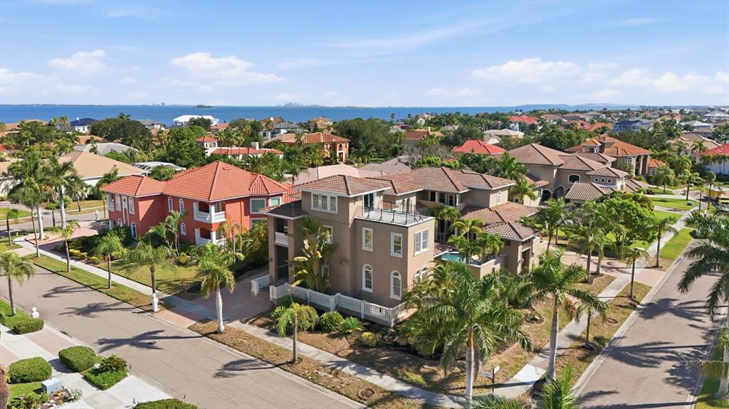 An aerial view of a multi-story tan house with a rooftop deck in a neighborhood — 1304 JUMANA LOOP, APOLLO BEACH, FL