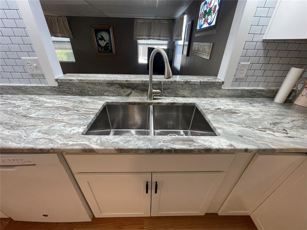 A kitchen sink with a stainless steel faucet set in a marble countertop — 504 49TH C AVENUE DRIVE E, BRADENTON, FL