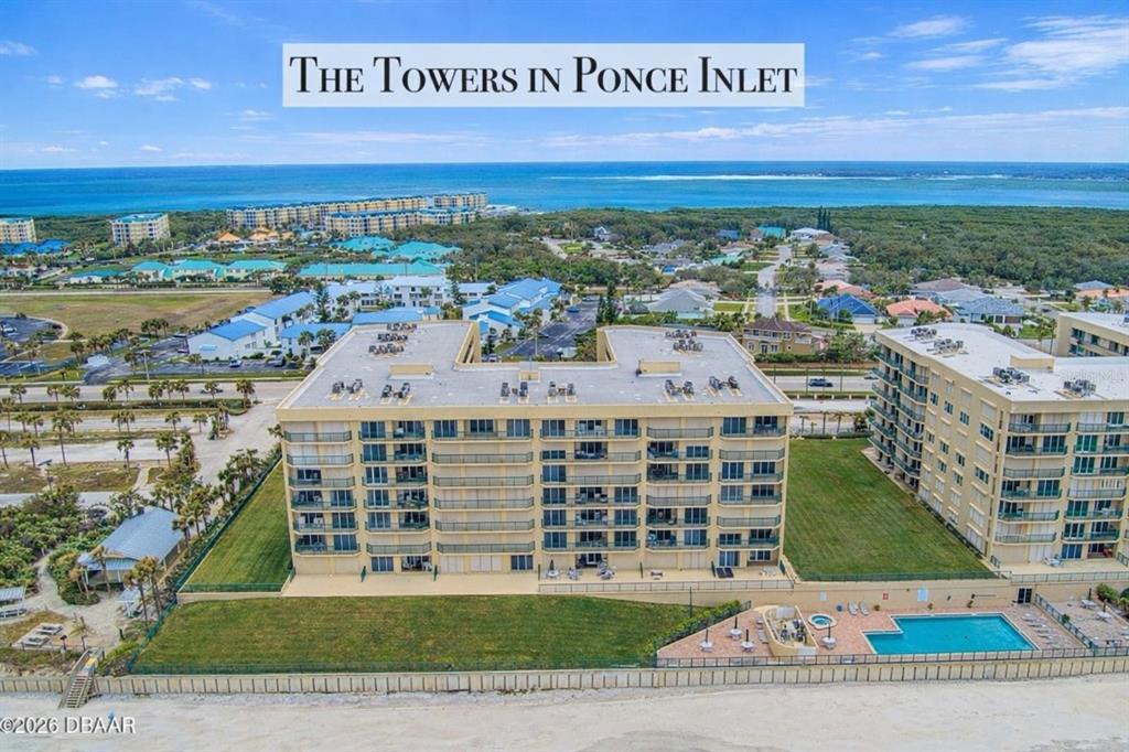 An aerial view shows a multi-story beachfront condominium complex with a pool and ocean — 4575 S ATLANTIC AVENUE UNIT 6303, PORT ORANGE, FL
