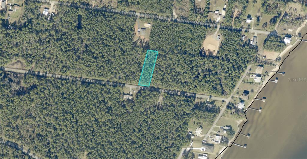 An aerial view shows a rectangular plot of land outlined in blue amidst wooded terrain — 14-1S-28-0000-00113-0000 SEA BREEZE LANE, MILTON, FL