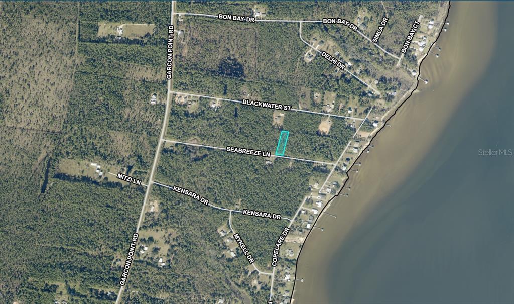 This is an aerial map showing a highlighted rectangular land parcel near a body of water — 14-1S-28-0000-00113-0000 SEA BREEZE LANE, MILTON, FL