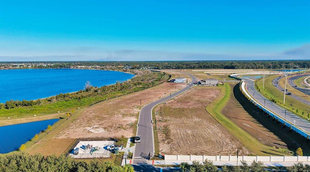An aerial view shows a long wooden dock extending into a large blue lake — 19309 LOCHSIDE LANE, MOUNT DORA, FL