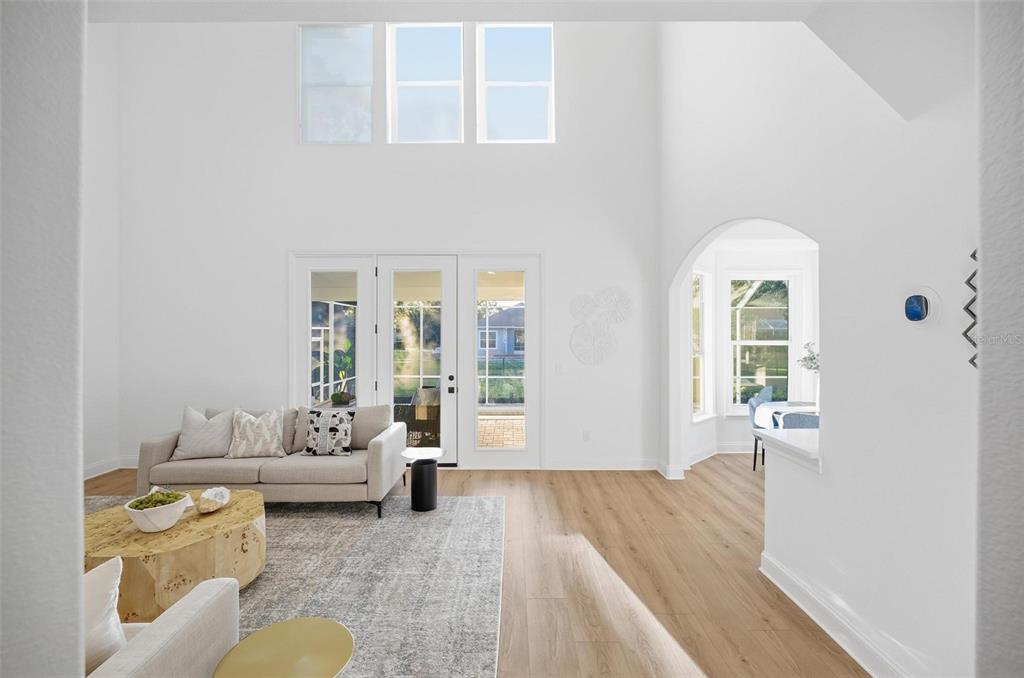 A bright living room features high ceilings, light wood floors, and a glass-paned door wall — 41 OLD OAK DRIVE S, PALM COAST, FL