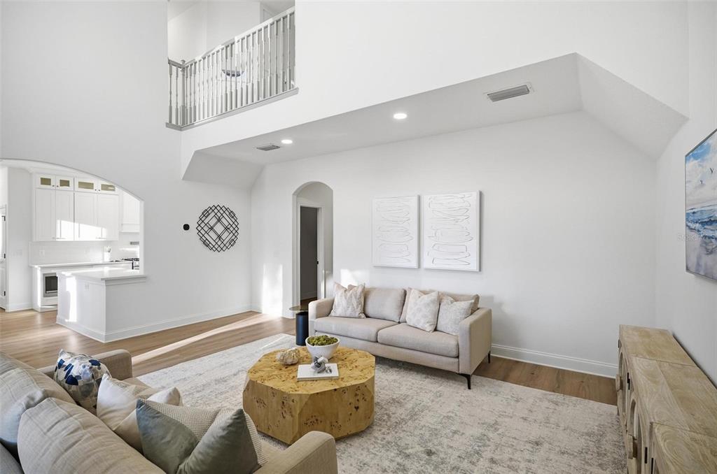 A bright living room with high ceilings, a beige sofa, and a large wooden coffee table — 41 OLD OAK DRIVE S, PALM COAST, FL