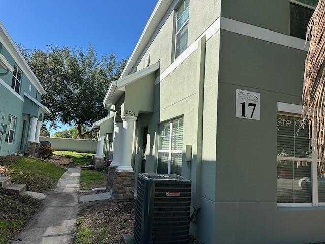 A side view of a light green two-story townhouse with a prominent number 17 sign — 10931 KEYS GATE DRIVE, RIVERVIEW, FL