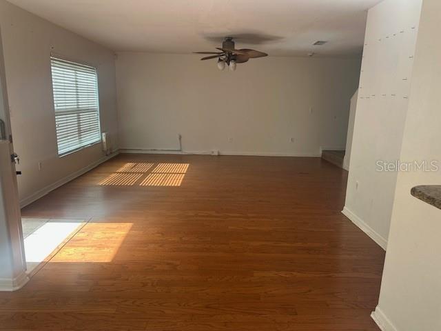 An empty living room with wood-look flooring, a ceiling fan, and a window with blinds — 10931 KEYS GATE DRIVE, RIVERVIEW, FL
