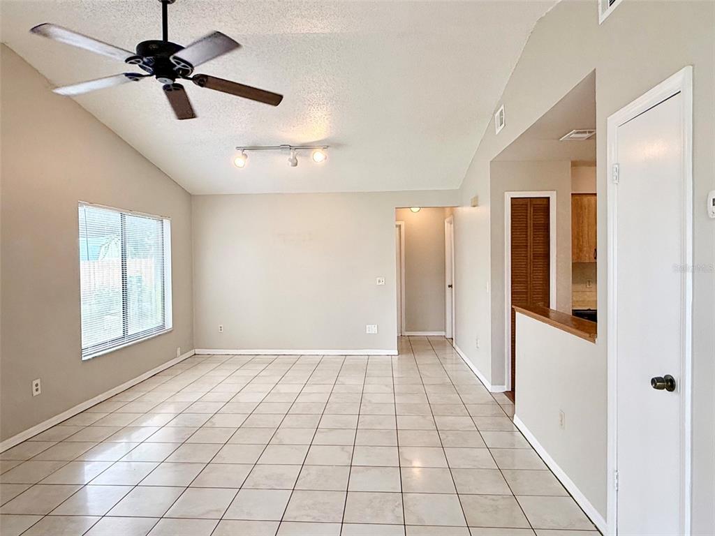 The exterior of a tan concrete block house features a sliding glass door and window — 608 E WARREN AVENUE, LONGWOOD, FL