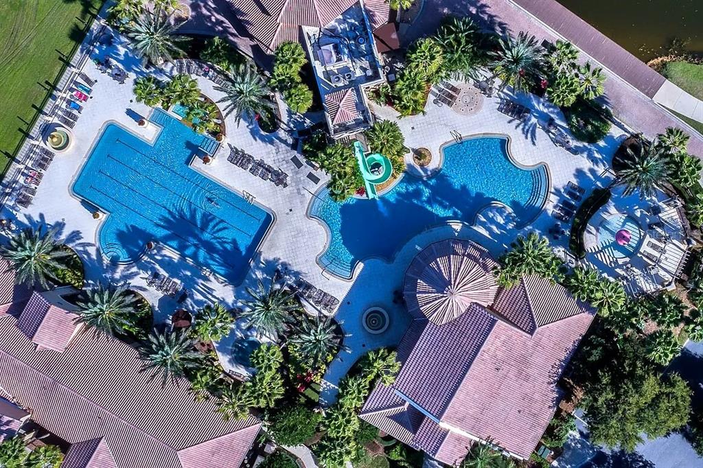 An aerial view of a suburban neighborhood featuring houses surrounding a lake under a cloudy sky — 3839 GOLDEN FEATHER WAY, KISSIMMEE, FL