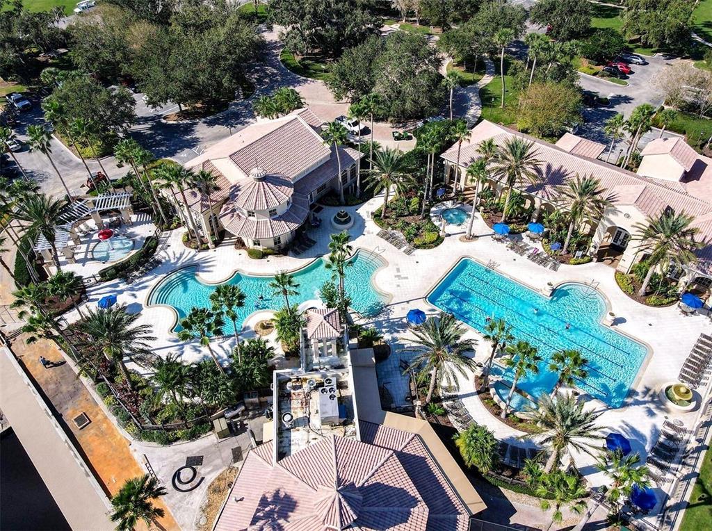 An aerial view of a residential neighborhood featuring houses with tile roofs near a lake — 3839 GOLDEN FEATHER WAY, KISSIMMEE, FL