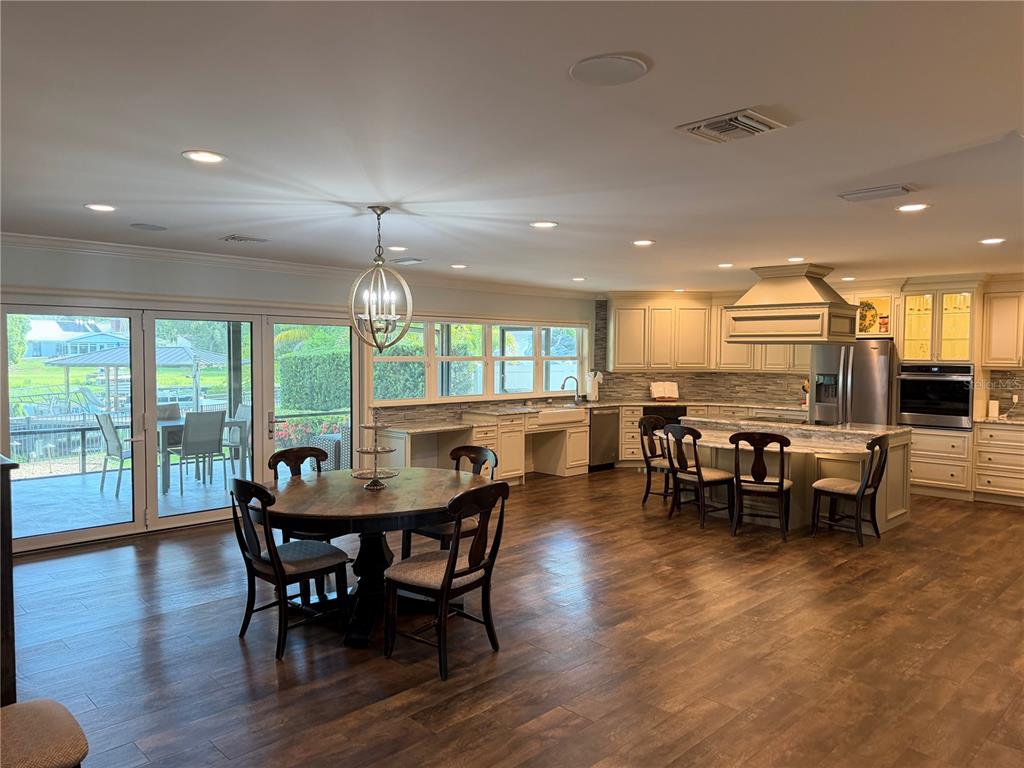 A single-story gray brick house features a two-car garage and a large asphalt driveway — 10715 CARROLLWOOD DRIVE, TAMPA, FL