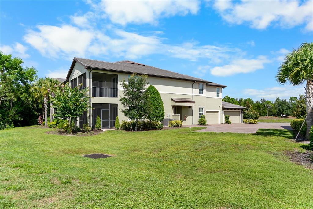 A two-story multi-family building with a screened-in porch and attached garages on a lawn — 7342 DIVOT LOOP, LAKEWOOD RANCH, FL