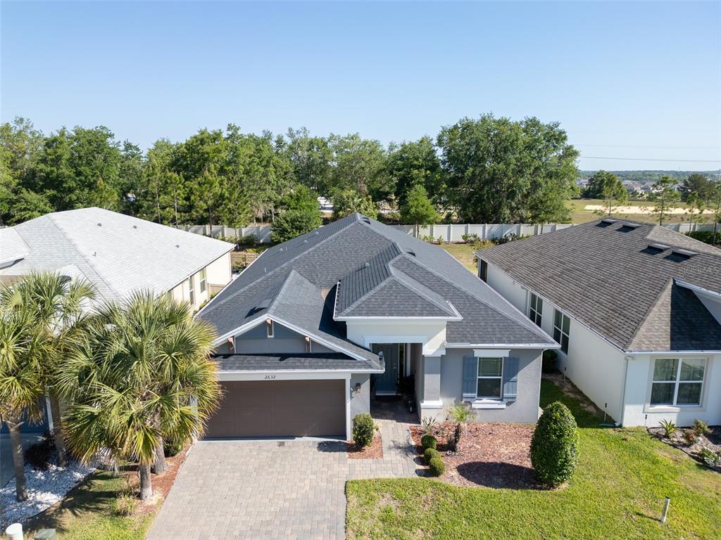 An aerial view of a single-story gray house with a dark shingled roof and driveway — 2632 PINNACLE LANE, CLERMONT, FL