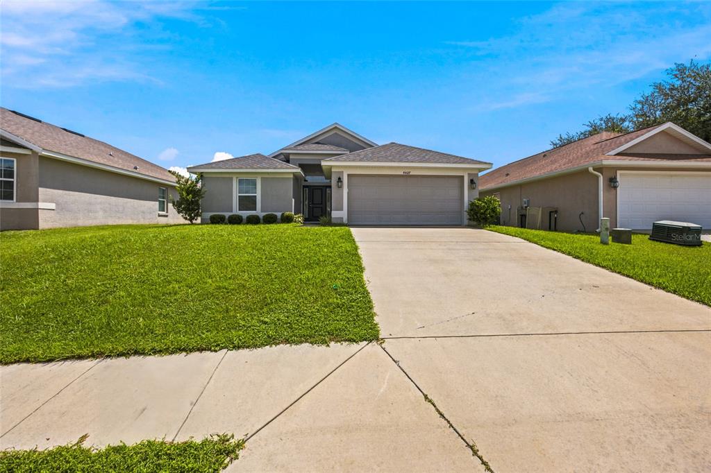 A single-story suburban house with a gray exterior, a two-car garage, and a concrete driveway — 4427 NW 2ND COURT, OCALA, FL