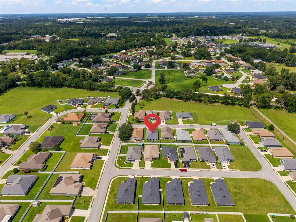 An aerial view shows a suburban neighborhood with single-family homes and green lawns — 4427 NW 2ND COURT, OCALA, FL