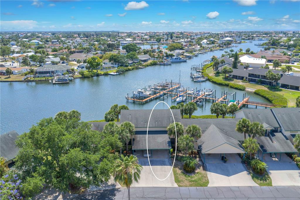 An aerial view shows a townhouse with a covered carport and a nearby boat dock — 614 YARDARM DRIVE UNIT 7, APOLLO BEACH, FL