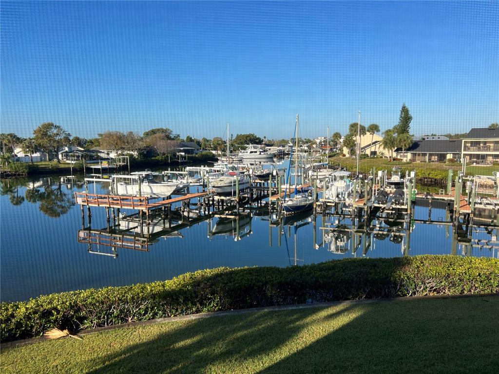 A view of a canal with multiple docked boats and surrounding residential properties — 614 YARDARM DRIVE UNIT 7, APOLLO BEACH, FL