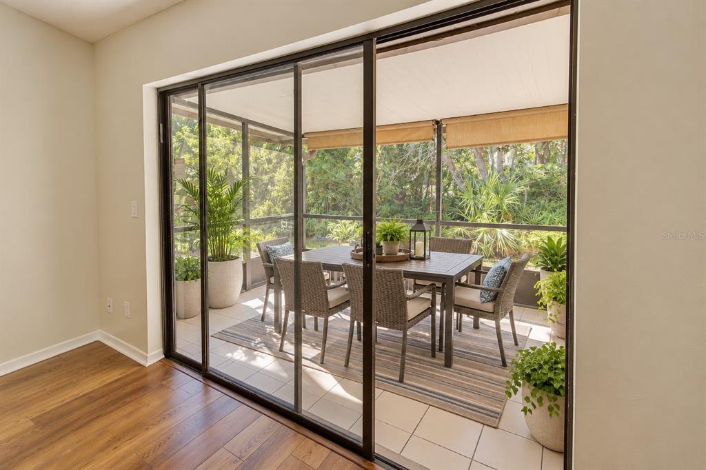 An entryway with a wood-look floor leads to a living area with a sliding glass door — 506 CLUB DRIVE, WINTER SPRINGS, FL