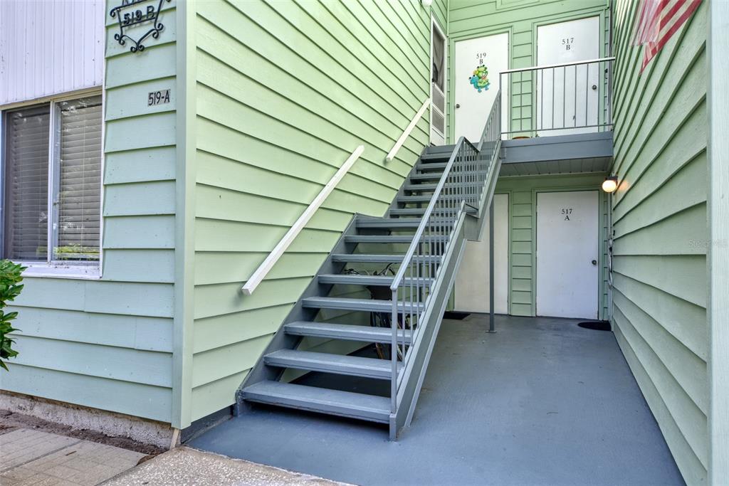 An exterior view of a light green building with a metal staircase leading to upper units — 519 MIDWAY DRIVE UNIT A, OCALA, FL
