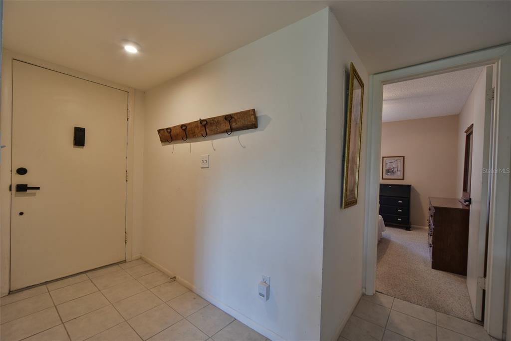 An entryway with a tiled floor, a coat rack on the wall, and a doorway — 519 MIDWAY DRIVE UNIT A, OCALA, FL