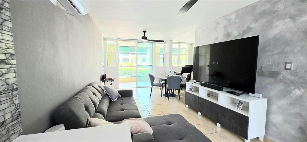 A living room features a gray sectional sofa, a large television on a stand, and a dining area — Carr. 187 KM 23.6 AQUATIKA A-8 UNIT 1601, LOIZA, PR