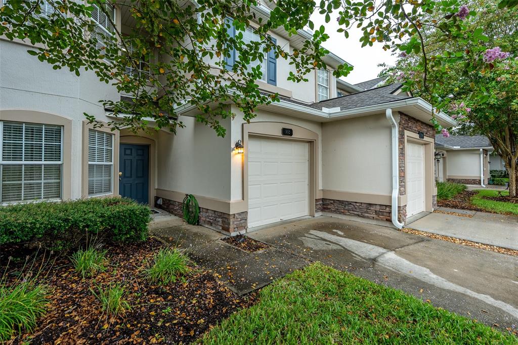 A kitchen features wood cabinets, granite countertops, a black stove, and a microwave — 332 WOODED CROSSING CIRCLE, ST AUGUSTINE, FL