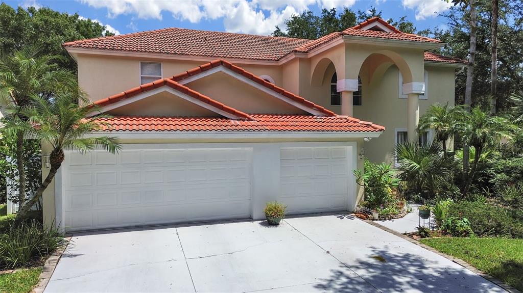 A two-story house with a terracotta tile roof and a two-car garage — 10212 GARDEN ALCOVE DRIVE, TAMPA, FL