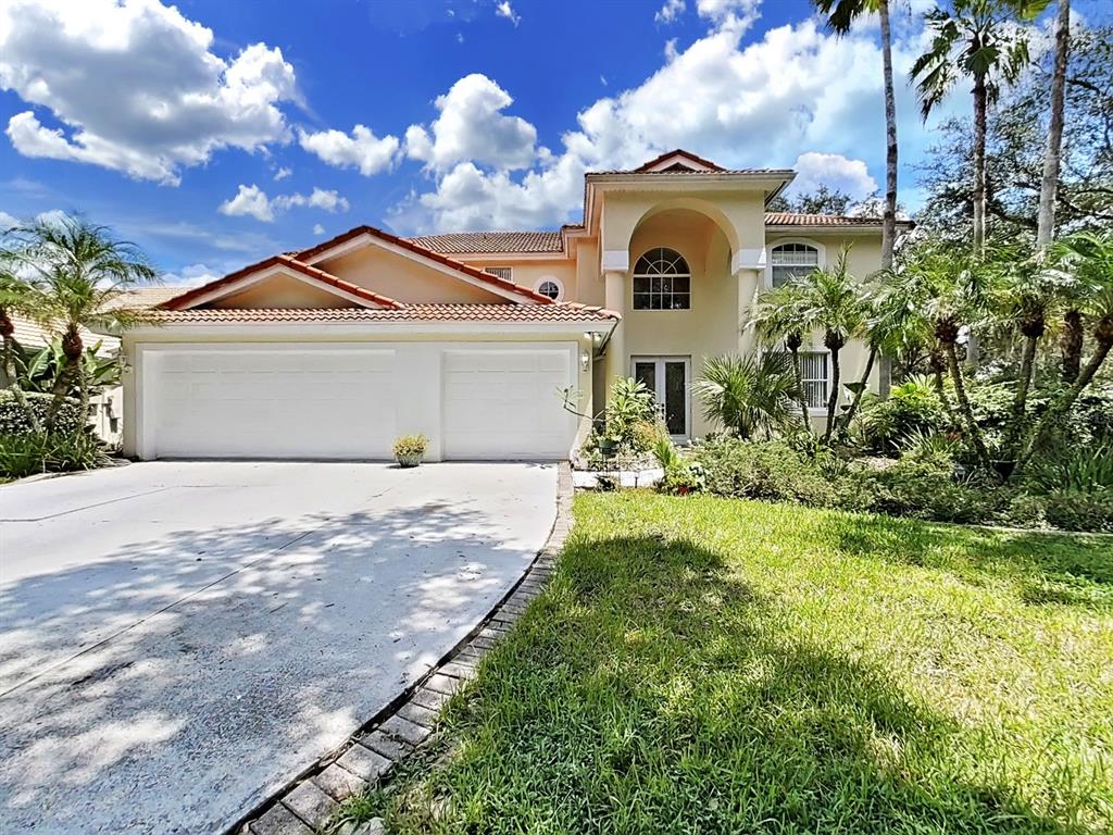 A two-story house with a two-car garage, arched entryway, and a tile roof — 10212 GARDEN ALCOVE DRIVE, TAMPA, FL