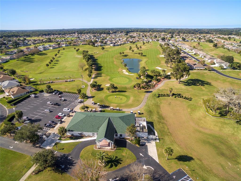 An aerial view shows a community clubhouse with a large swimming pool and parking lot — 1921 NW 50TH CIRCLE, OCALA, FL