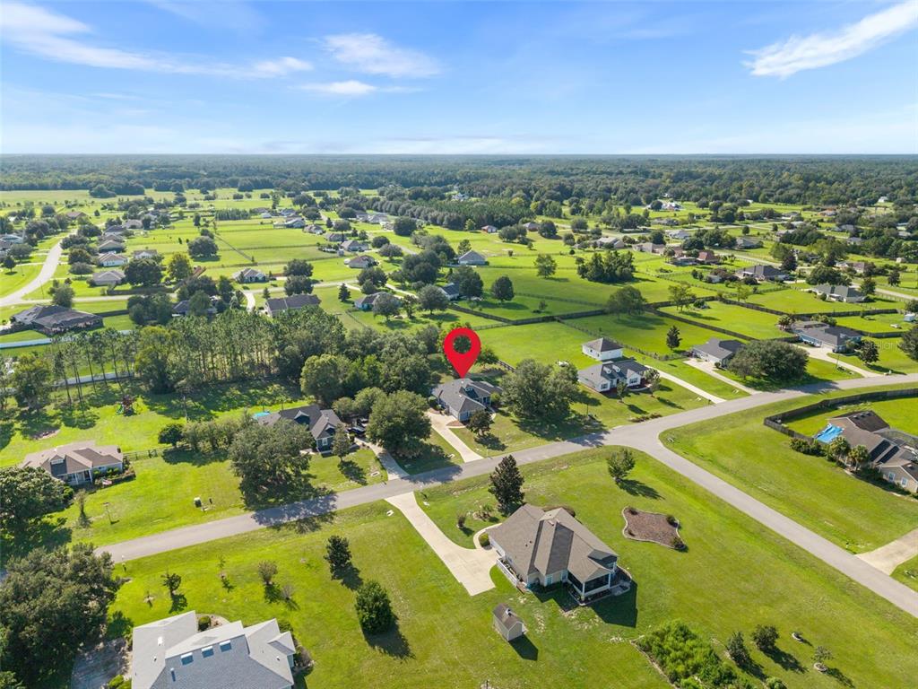 An aerial view shows a single-family home with a red location pin on a lot — 9978 SW 98TH TERRACE, GAINESVILLE, FL