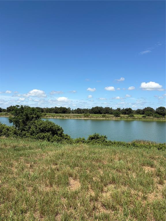 An aerial view shows a large green pond bordered by a dirt road and trees — 10349 COUNTY ROAD 555, FORT MEADE, FL