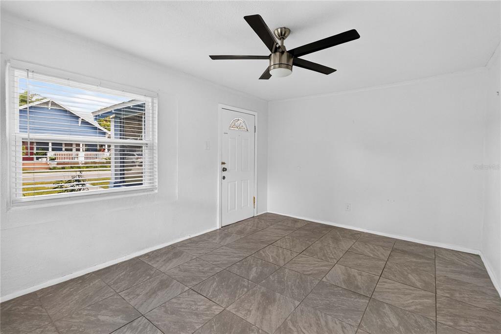 A room with white walls, tiled flooring, a ceiling fan, and a window facing outside — 1103 BRACK STREET, KISSIMMEE, FL
