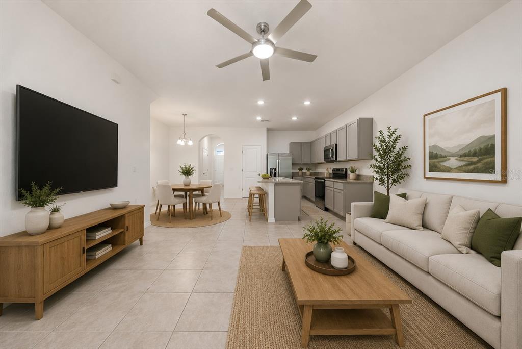 A modern kitchen features gray cabinets, granite countertops, a central island, and stainless steel appliances — 1574 HUBBELL ROAD, WESLEY CHAPEL, FL