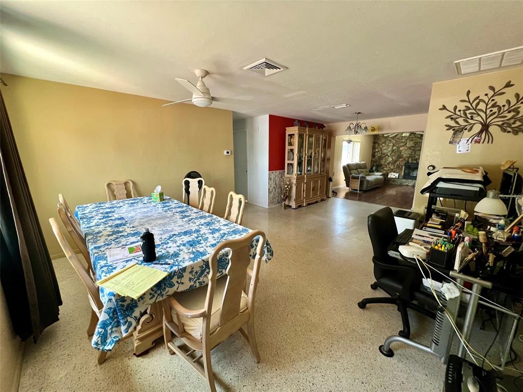 A dining area with a patterned tablecloth and a nearby desk in an open room — 2133 INDIGO DRIVE, CLEARWATER, FL