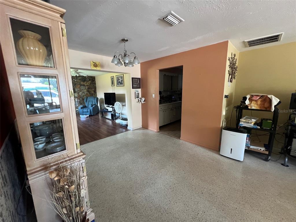 A dining area with terrazzo floors connects to a living room and a kitchen — 2133 INDIGO DRIVE, CLEARWATER, FL