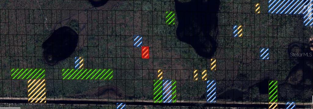 This is a map showing various land parcels highlighted in different colors over a satellite view — N/A, INDIANTOWN, FL