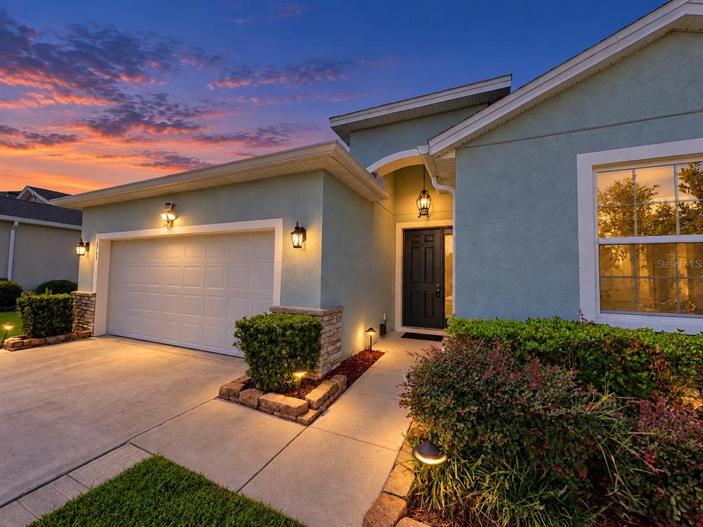 A light blue single-story house with a white garage door and a concrete driveway — 5703 SW 50TH AVENUE, OCALA, FL