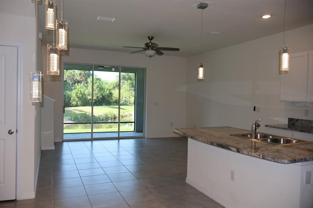 A kitchen features white cabinets, granite countertops, stainless steel appliances, and a central island — 8748 MILESTONE DRIVE, SARASOTA, FL