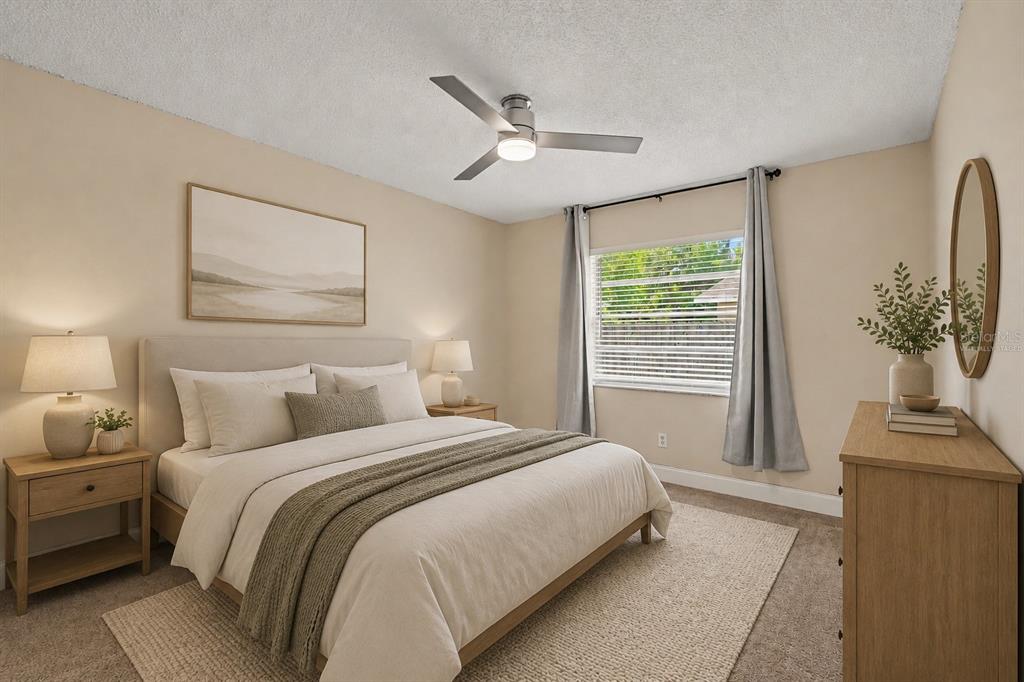 A bedroom features a bed with neutral bedding, two nightstands, a dresser, and a ceiling fan — 5733 66TH LANE N, ST PETERSBURG, FL