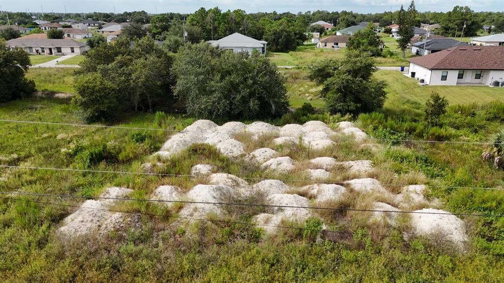 An aerial view shows a vacant lot covered in numerous small piles of white dirt — 4427 24TH STREET SW, LEHIGH ACRES, FL