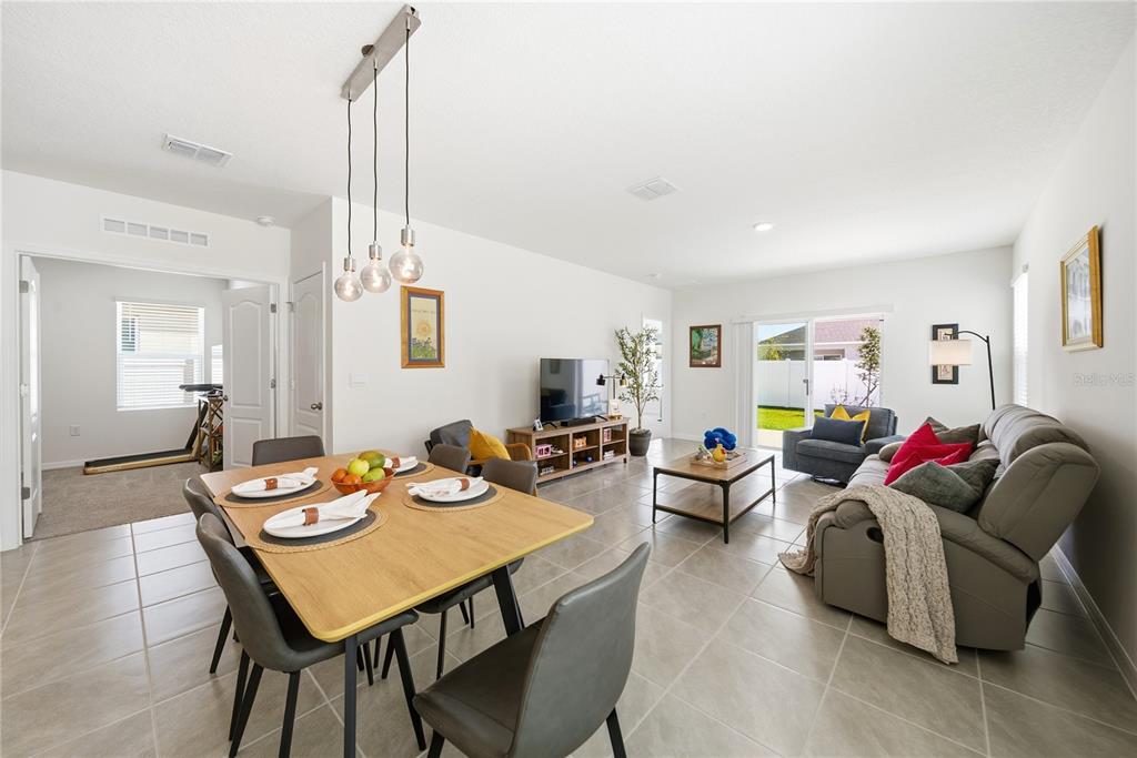 A single-story house with a two-car garage and a covered entryway at sunset — 7104 CATTLE EGRET DRIVE, ST CLOUD, FL