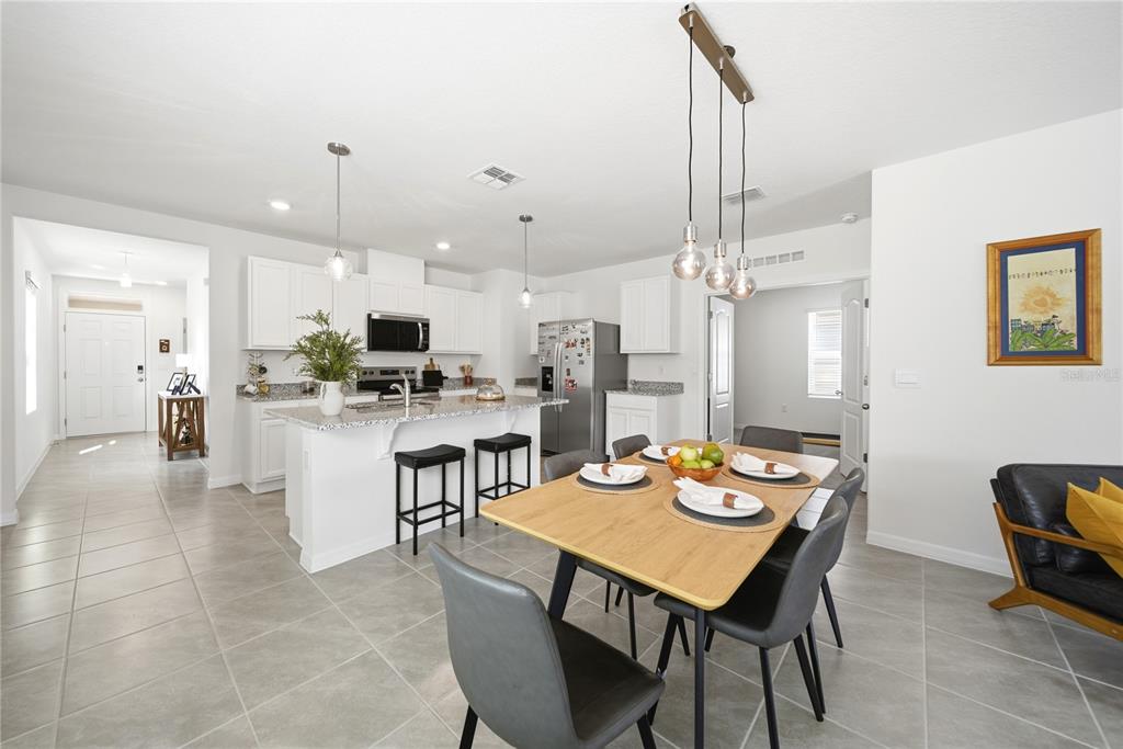 A bright entryway features a console table, tiled floors, and a view into the home — 7104 CATTLE EGRET DRIVE, ST CLOUD, FL