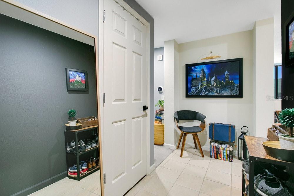 An entryway features a white door, a large floor mirror, and a framed wall painting — 322 E CENTRAL BOULEVARD UNIT 1008, ORLANDO, FL