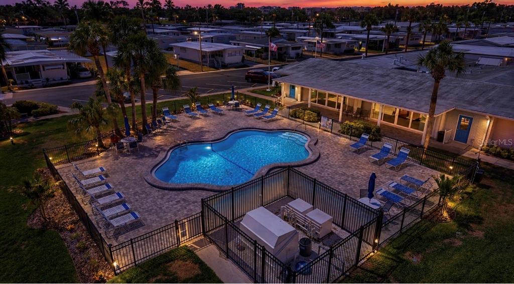 An aerial view of a community swimming pool surrounded by lounge chairs and a building — 2000 E BAY DRIVE UNIT 85, LARGO, FL