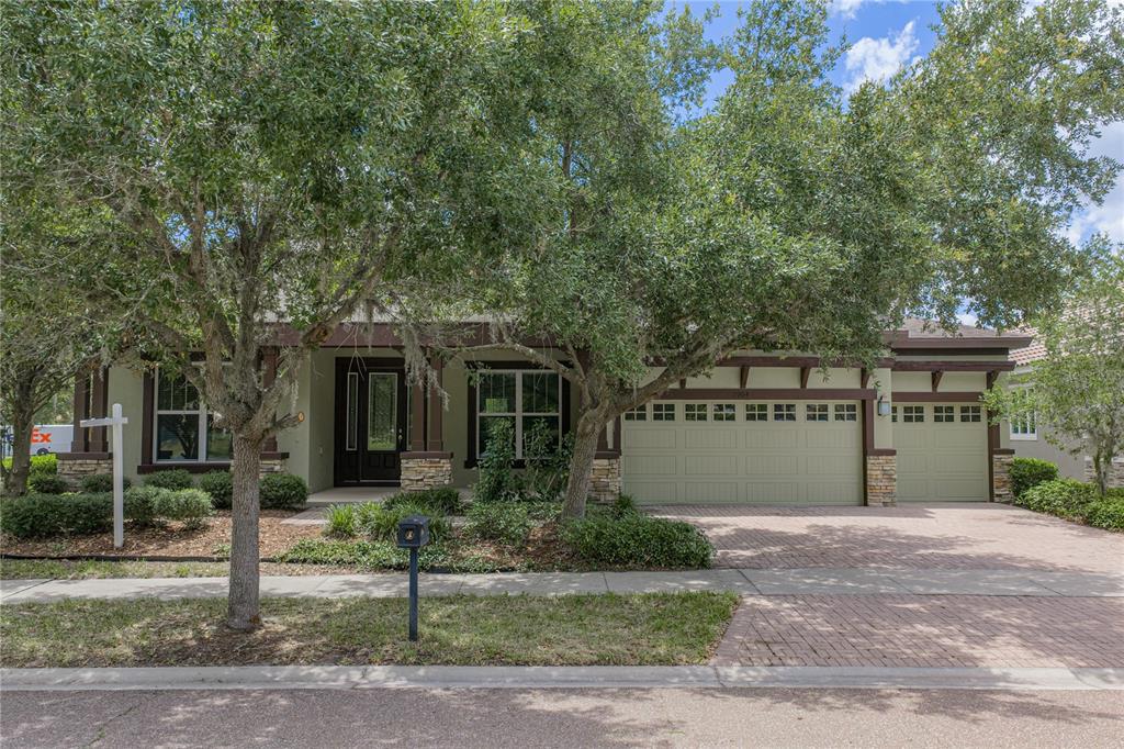 A single-story house with a brick driveway, stone accents, and a three-car garage — 5904 SHELL RIDGE DRIVE, LITHIA, FL