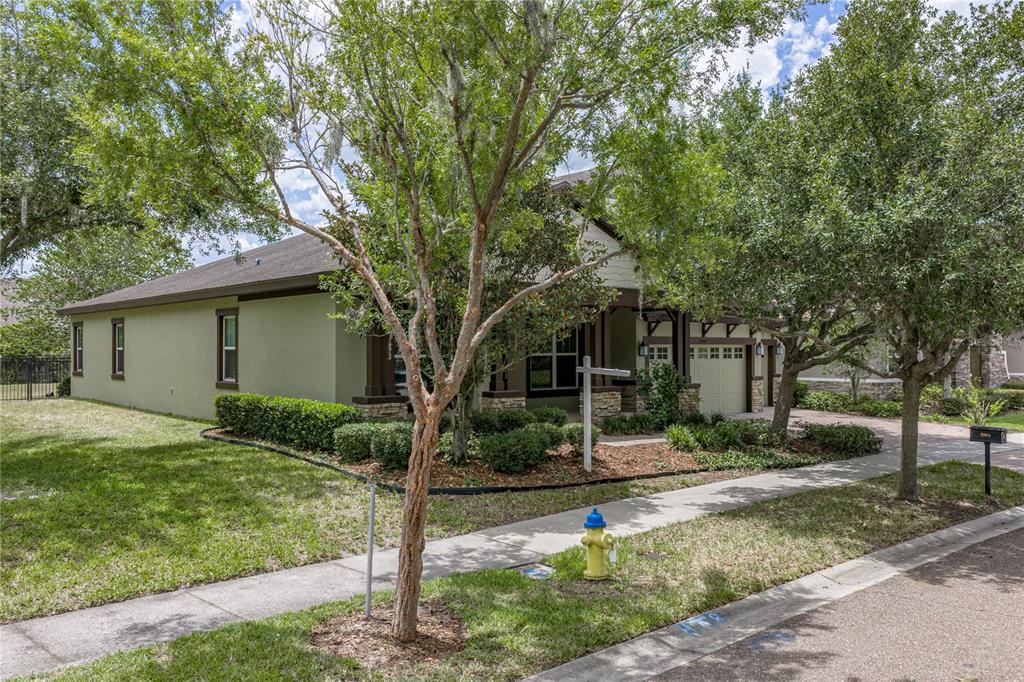 A single-story house with a green exterior, stone accents, and a front-facing garage — 5904 SHELL RIDGE DRIVE, LITHIA, FL